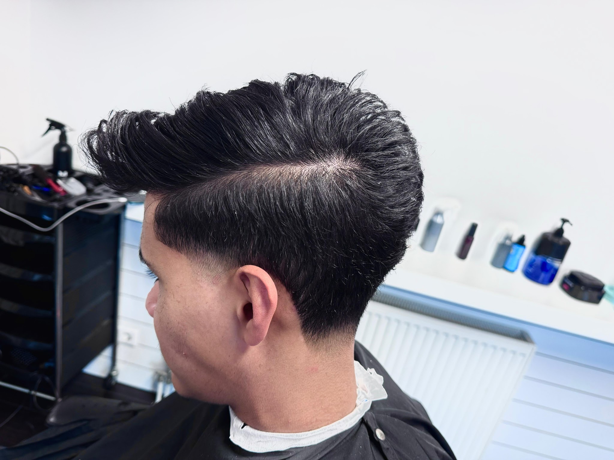 Hoge kuif met een taper fade, van opzij