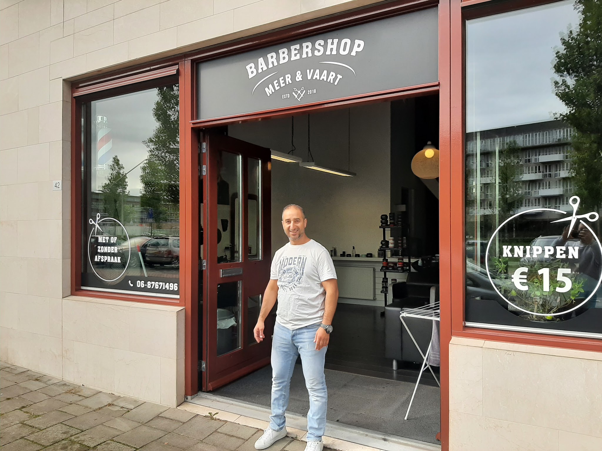 De zaak aan de Meer en Vaart 42: het grijze bord Barbershop Meer & Vaart boven de open deur, Rachid in de deuropening